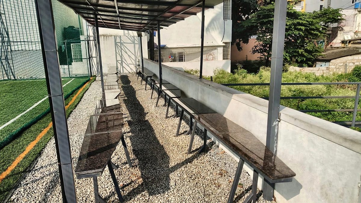 Covered seating with granite benches along the side of the pitch