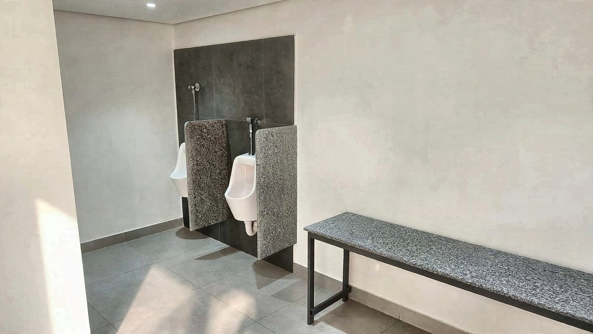 Washroom with urinals and a bench